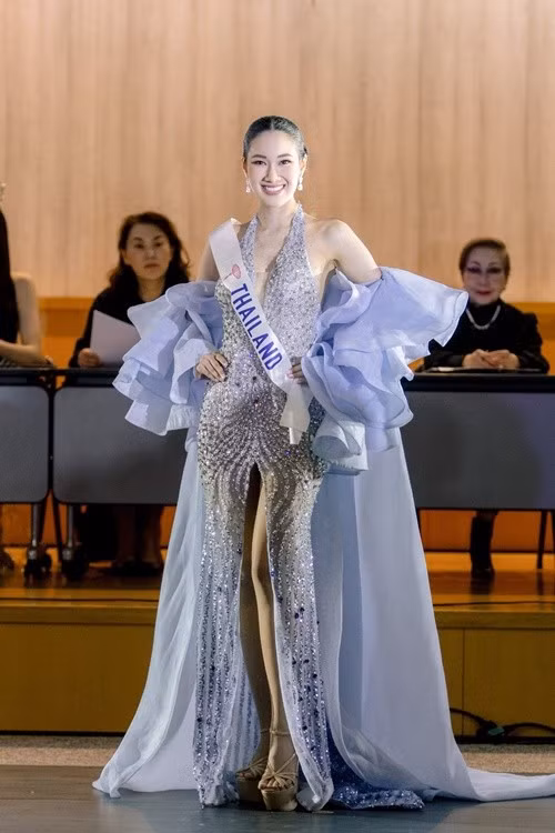 Jarupiya Boribalburibhand - đại diện Thái Lan khoe vẻ gợi cảm ở bán kết trong phần thi trang phục dạ hội. Người đẹp chọn mẫu váy xẻ tà cao, nổi bật với chi tiết áo choàng và tay bèo nhún màu xanh nhạt, mang lại vẻ ngoài vừa sang trọng vừa quyến rũ. Ảnh: Miss International.