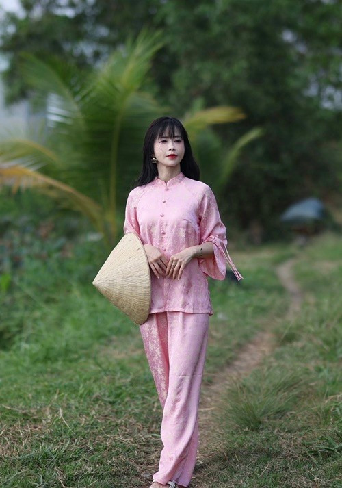 Khi diện áo dài hồng pastel, tay cầm nón lá giữa không gian làng quê mộc mạc, nữ võ sĩ lại ghi điểm bởi vẻ dịu dàng, đậm chất Á Đông.