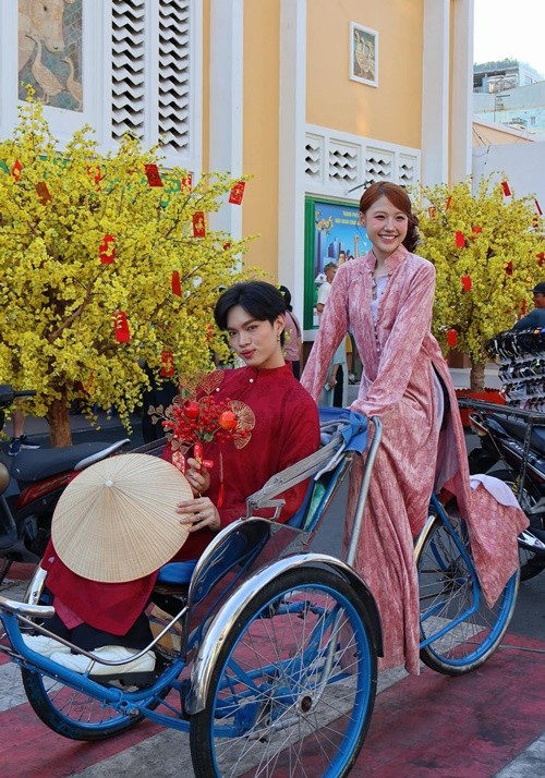 Xuống phố du xuân sớm, Pháp Kiều diện áo dài đỏ trầm, ngồi trên xích lô, tay cầm nón tạo điểm nhấn hoài niệm giữa không gian ngày xuân. Uyển Ân lựa chọn áo dài hồng phấn mềm mại, họa tiết nhẹ nhàng, tôn vẻ nữ tính, dịu dàng. Ảnh: FB Pháp Kiều.