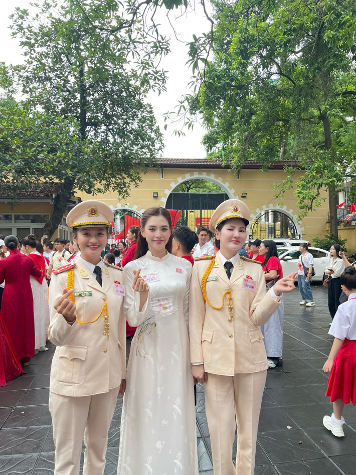 Hoa hậu Tiểu Vy diện áo dài trắng với điểm nhấn trên ngực trái là chiếc huy hiệu cài áo hình lá cờ Việt Nam. Ảnh: Sen Vàng.