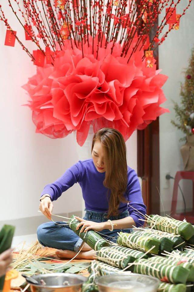 Mỗi dịp xuân về, Mỹ Tâm lại cùng gia đình quây quần gói bánh chưng, làm mứt Tết – những việc làm quen thuộc nhưng mang đến cảm giác ấm áp, trọn vẹn. Trong trang phục đời thường giản dị, mái tóc buông nhẹ, 'họa mi tóc nâu' ghi điểm bởi vẻ đẹp mộc mạc, gần gũi khi tự tay xếp lá dong, cho nếp, đậu, thịt vào khuôn bánh.