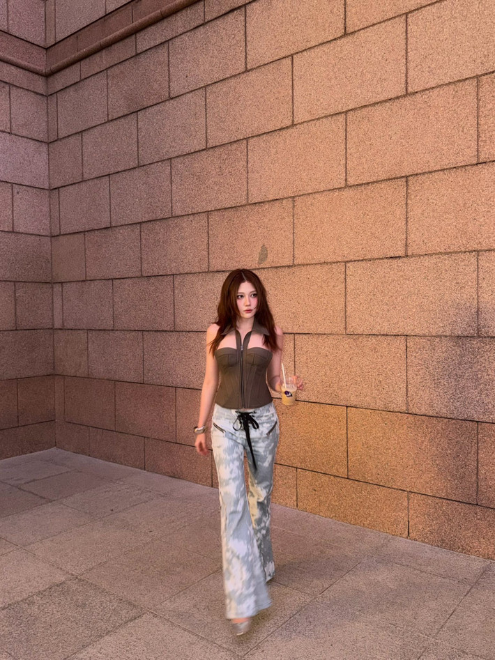 Uyển Ân diện áo corset cúp ngực, quần jeans họa tiết loang ống rộng khi xuống phố mới đây.