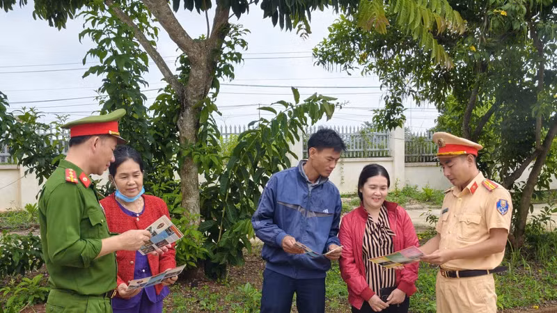 Cán bộ Công an xã Đắk Song phát tờ rơi tuyên truyền cho người dân.