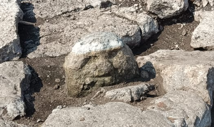 Bức tượng cao khoảng 45 cm, khắc họa một khuôn mặt giống người với hốc mắt sâu, mũi tẹt và môi có khe hở, cùng chiếc cằm nhọn. Ảnh: @Viện Nhân chủng và Lịch sử Quốc gia Mexico.