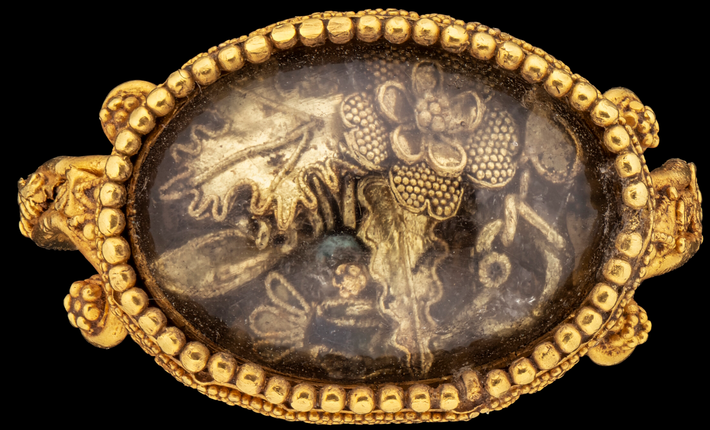 Bó hoa nổi bật với một bông hoa vàng lớn với những hạt vàng dát mỏng ở giữa, những cánh hoa thì được viền tinh xảo, cùng những hạt vàng dát mỏng hơn ở những chiếc lá sồi rộng bên dưới. Ảnh: @Bảo tàng J. Paul Getty.