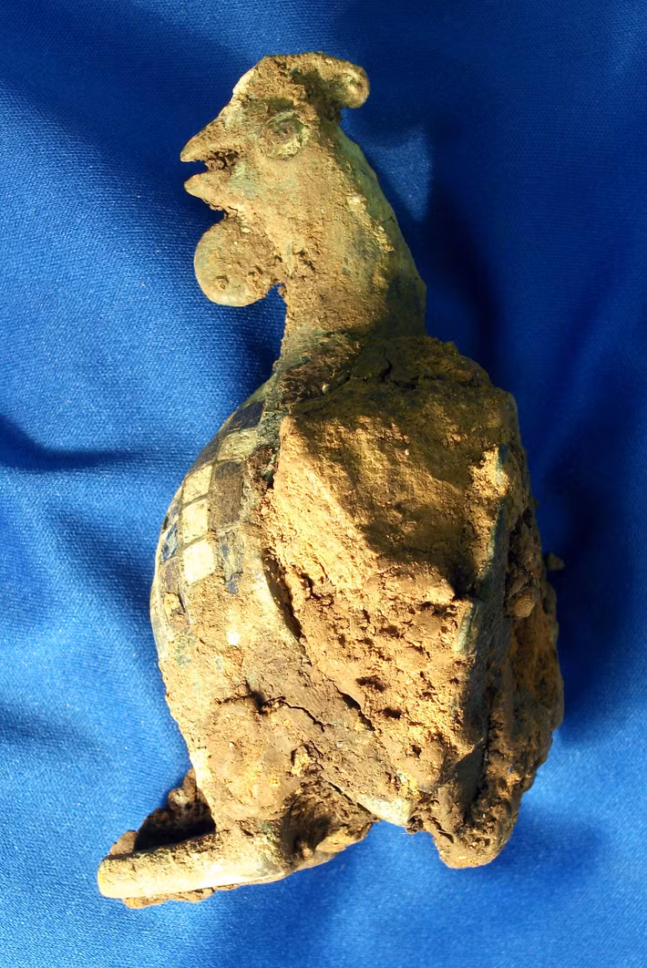 Tượng gà trống này cao chưa đến 12 cm, nó được phát hiện trong một ngôi mộ bé gái hai tuổi thuộc thời La Mã cổ đại, ước tính có niên đại từ thế kỷ thứ 2 Sau Công Nguyên. Ảnh: @Cotswold Archaeology.