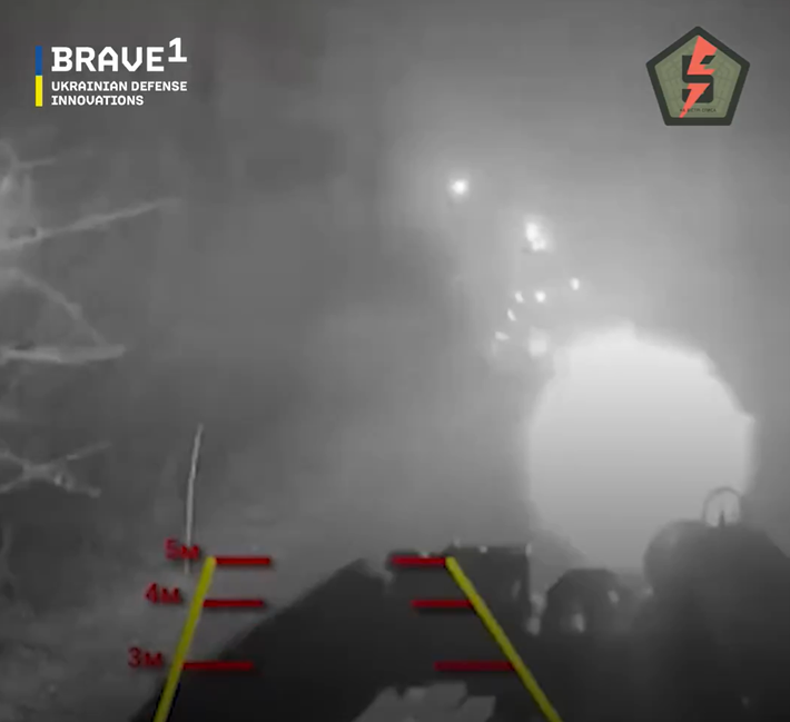 Người điều khiển xe robot tự hành mặt đất (UGV) thực hiện nhiệm vụ từ khoảng cách an toàn, loại bỏ rủi ro cho con người, và chứng minh một trong những ưu điểm chính của chiến tranh robot, đó là khả năng gây sát thương mà không khiến binh lính phải đối mặt với nguy hiểm đến tính mạng. Ảnh: @FedorovMykhailo.