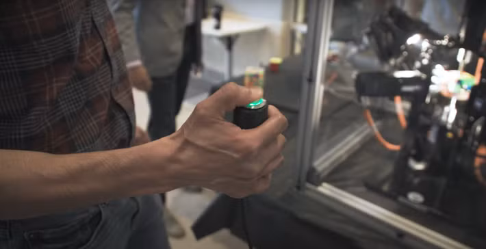 Trong một video, có thể thấy có một vị khách đang cầm một nút bấm màu xanh lá cây phát sáng, nút này đã kết nối với hệ thống robot Purdubik's Cube đang giữ khối Rubik xáo trộn các màu. Và khi người này nhấn nút, sẽ có tiếng kêu vang lên ngắn, rồi ngay lập tức câu đố khối Rubik đã được giải quyết. Ảnh: @Đại học Purdue.