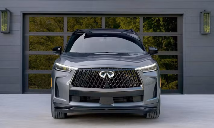 QX60 2026 giữ nguyên phong cách sang trọng vốn có, nhưng được làm mới ở một số chi tiết ngoại thất. Logo Infiniti phía trước nay có khả năng phát sáng, tạo điểm nhấn nhận diện về đêm. Lưới tản nhiệt thiết kế lại, cụm đèn pha LED mảnh hơn tích hợp dải LED ban ngày kiểu kỹ thuật số. Cản trước và sau được tái thiết kế, giúp tổng thể xe trông thanh thoát nhưng vẫn chắc chắn.