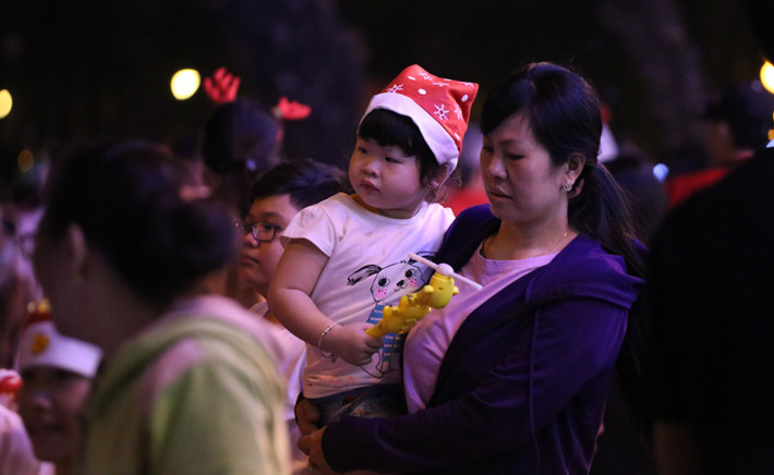 Những đứa trẻ được người thân đưa xuống phố để vui chơi Giáng sinh.