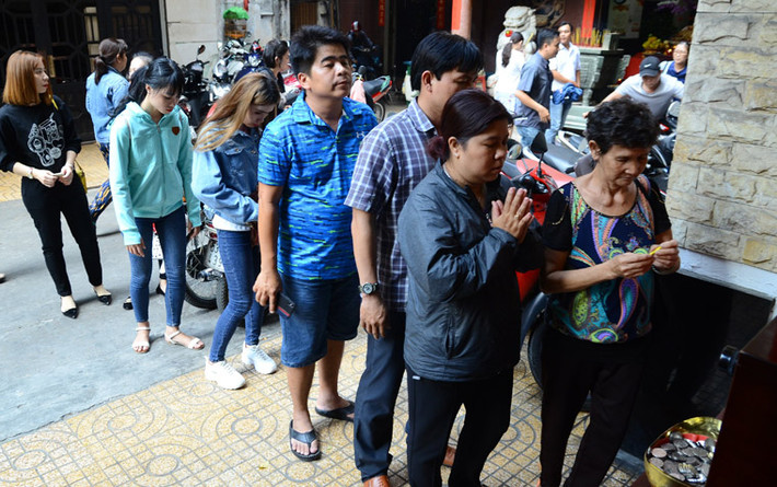 Bất chấp nắng nóng đầu mùa khô miền Nam, người dân vẫn trật tự xếp hàng chờ đến lượt xin xăm bằng máy.