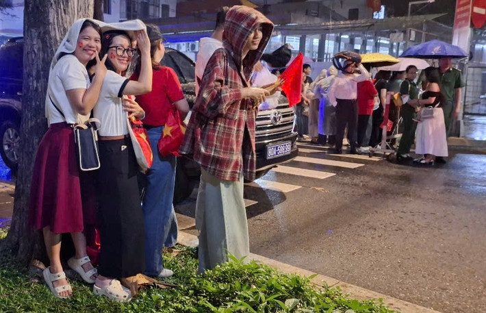 Cơn mưa bất chợt cũng không làm giảm đi sự nhiệt tình của người dân