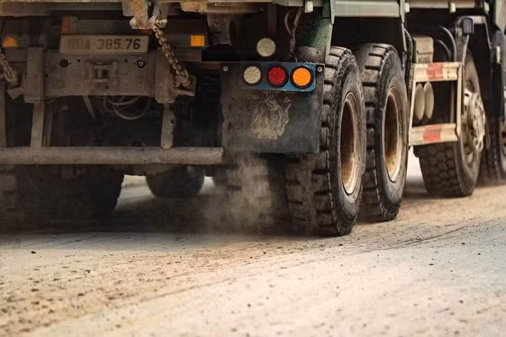 Đất cát theo bánh xe bị kéo ra ngoài, rơi vãi dọc tuyến phố. Không ít phương tiện di chuyển mà không che chắn kỹ, khiến lượng đất phát tán ngày càng nhiều.