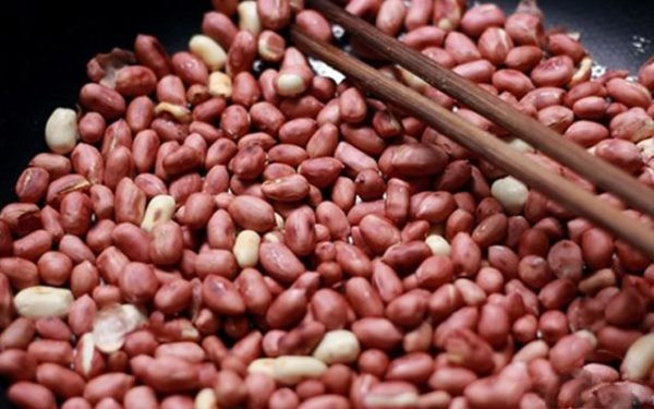 Cách làm sữa đậu phộng: Trước hết, bạn cho lạc vào chảo rang đến khi chín vàng rồi cho vào ủ và tách vỏ. Ảnh: agiadinh.