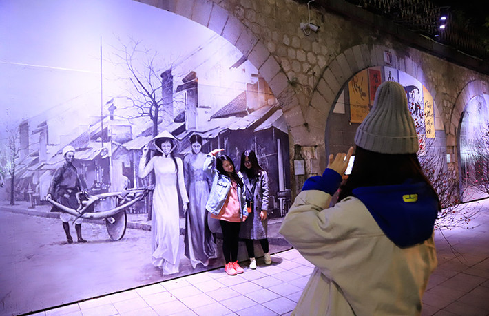 Phố bích họa Phùng Hưng lung linh trong đêm, thu hút được nhiều bạn trẻ đến chụp ảnh.