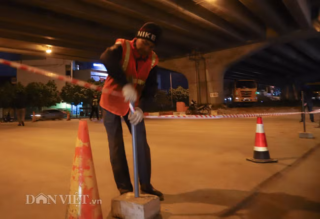 Các công nhân dùng dây phản quang để ngăn người tham gia giao thông vào khu vực đang thi công.