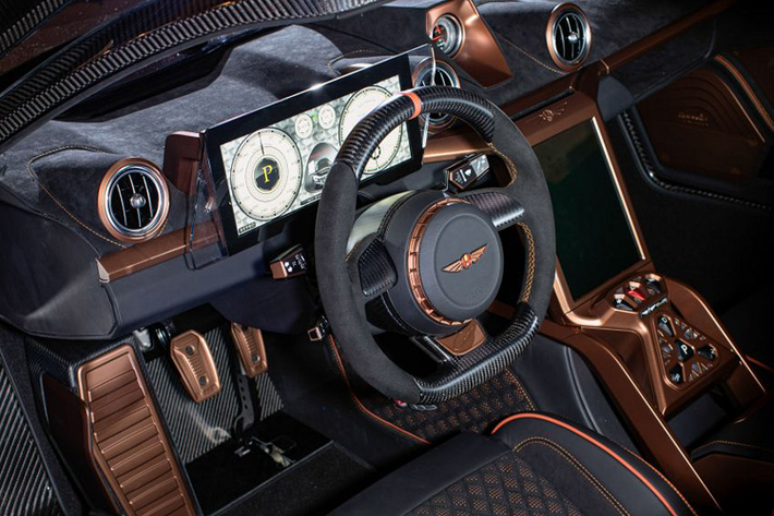 Bên trong nội thất, chiếc GT cũng được vị chủ nhân chọn phong cahs trang trí với tông màu tím/trắng và các điểm nhấn bằng đồng. Vô lăng xe được làm bằng sợi carbon và cũng được hoàn thiện bằng cách điểm nhấn màu đồng