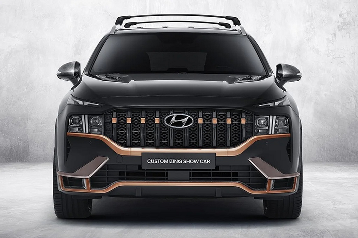 Diện mạo của SantaFe N-Performance trông mạnh mẽ và hầm hố hơn khi lưới tản nhiệt dạng tổ ong nguyên bản được thay thế bằng thiết kế gồm nhiều thanh kim loại cỡ lớn xếp theo chiều dọc. Đi cùng với đó, các chi tiết viền mặt ca-lăng và cản trước tạo hình sắc sảo hơn và sơn màu vàng cát Sahara Beige. Ngoài ra, trên nắp capô xuất hiện thêm 2 chi tiết hốc hút gió làm từ vật liệu sợi carbon.