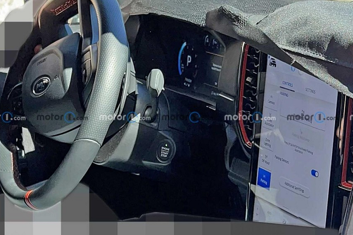 Qua hình ảnh chụp trên đường thử, có thể thấy phiên bản hiệu suất cao của Ford Ranger thế hệ mới được trang bị vô lăng vát đáy thể thao với điểm nhấn màu đỏ ở vị trí 12 giờ. Ngoài ra, ở đáy vô lăng còn dập dòng chữ "Raptor" màu đỏ. Đây là trang bị không hề có trên Ford Ranger 2022. Phía sau vô lăng xuất hiện lẫy chuyển số thể thao và bảng đồng hồ kỹ thuật số. Bên cạnh đó là màn hình thông tin giải trí dạng cảm ứng với kích thước lớn và đặt nằm dọc, tương tự Ford Ranger 2022.