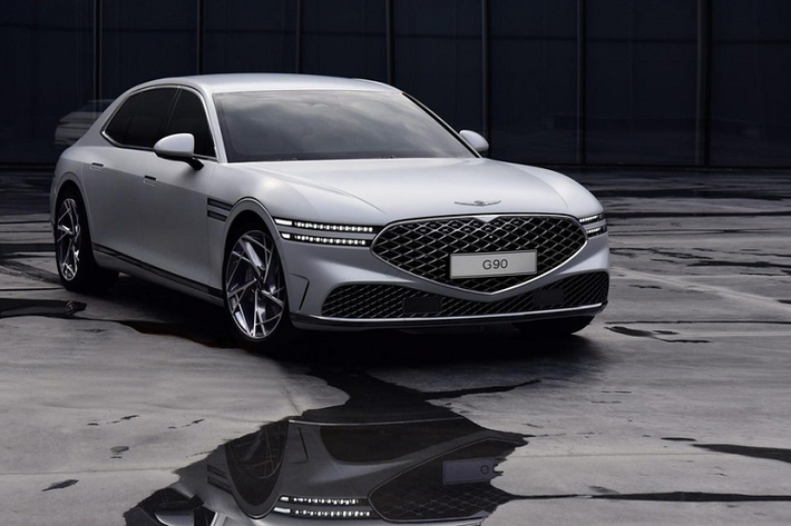 Được áp dụng ngôn ngữ thiết kế Athletic Elegance của thương hiệu, Genesis G90 2022 mới tiếp tục mang trên mình lưới tản nhiệt hình chiếc khiên Crest Grille đặc trưng. Theo thương hiệu Hàn Quốc, lưới tản nhiệt này được thiết kế với cấu trúc đa lớp mới. Bên cạnh đó là cụm đèn pha Two-Line, đi kèm 2 dải nằm song song với nhau, và nắp ca-pô hình vỏ sò, tạo cảm giác liền lạc cho đầu xe.