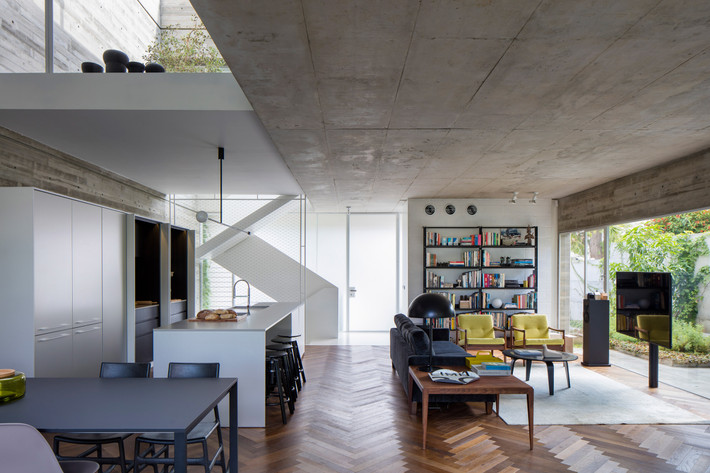 Phòng khách với chiếc tivi màn hình lớn và kệ sách cao 5 tầng.