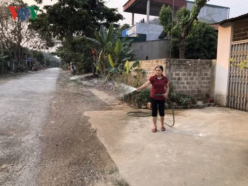 Người dân phải dùng nước tưới sân để giảm oi bức và đỡ bụi.