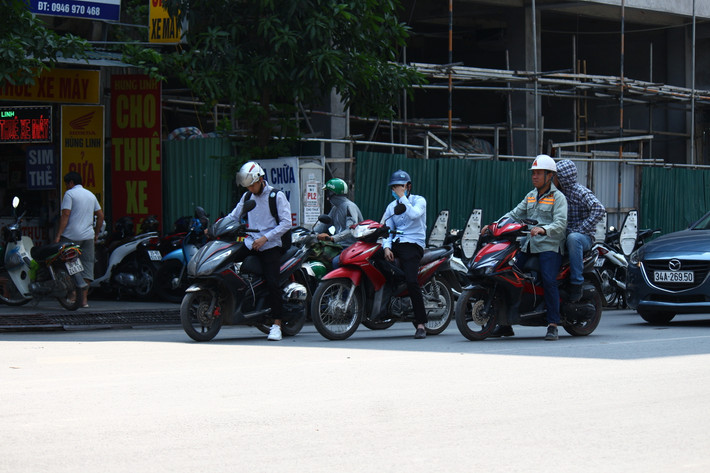 Tận dụng bóng râm của tòa nhà bên đường để tránh nắng.