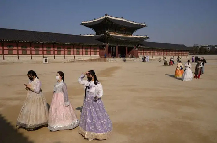 Các khách du lịch đeo khẩu trang tham quan cung điện Gyeongbokgung, một trong những điểm tham quan nổi tiếng nhất ở Seoul, Hàn Quốc.