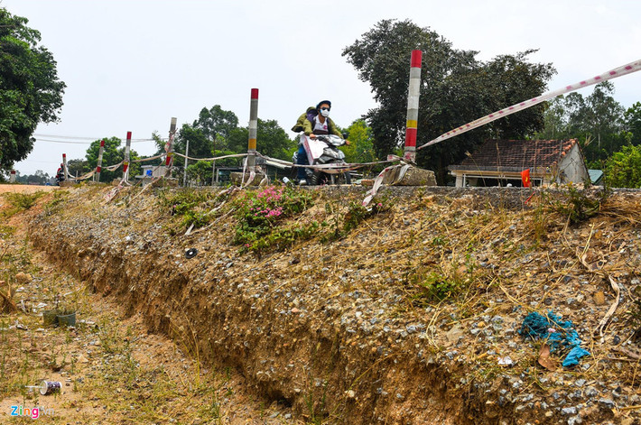 Một đoạn đường thi công dang dở tạo hố kéo dài hàng chục mét ven quốc lộ 1, xã Bình Hiệp, huyện Bình Sơn. Theo ông Phương, dự án gia hạn tiến độ nhiều lần là do người dân không chịu bàn giao mặt bằng. Họ cho rằng mức giá bồi thường theo quy định là quá thấp; một số trường hợp đòi đất tái định cư không đúng quy định..