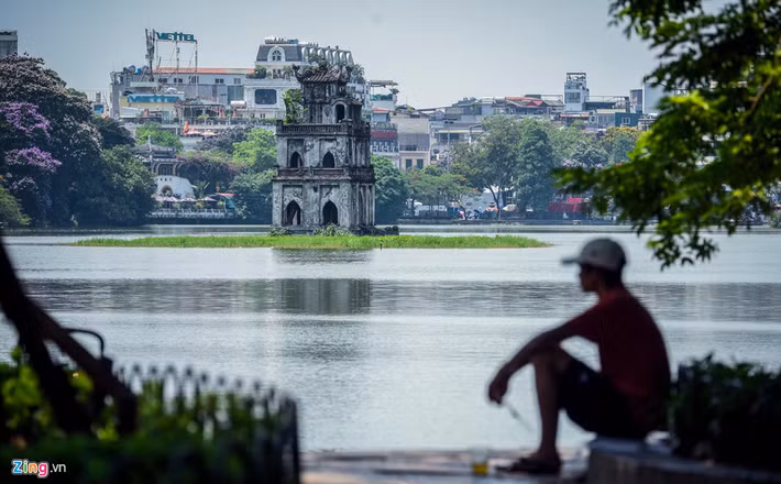 Người dân tranh thủ nghỉ ngơi, hóng mát ven Hồ Gươm.