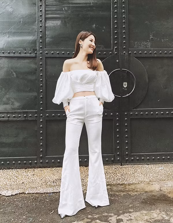 Diễm My đẹp tinh khôi khi phối hợp áo trễ vai màu trắng với quần loe cùng màu. Ảnh: hanghieuorder.