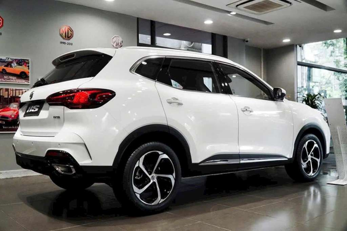 Trong khi đó, cản trước kết hợp đèn sương mù nằm dọc, hốc gió trung tâm rộng và tấm ốp gầm giả màu bạc. Phần nắp capo MG HS mới được thiết kế dốc xuống dưới, tương tự MG5. Ở phía sau, phần ống xả có thiết kế hầm hố hơn. Xe cũng được trang bị bộ mâm 5 chấu mới có kích thước 18 inch.