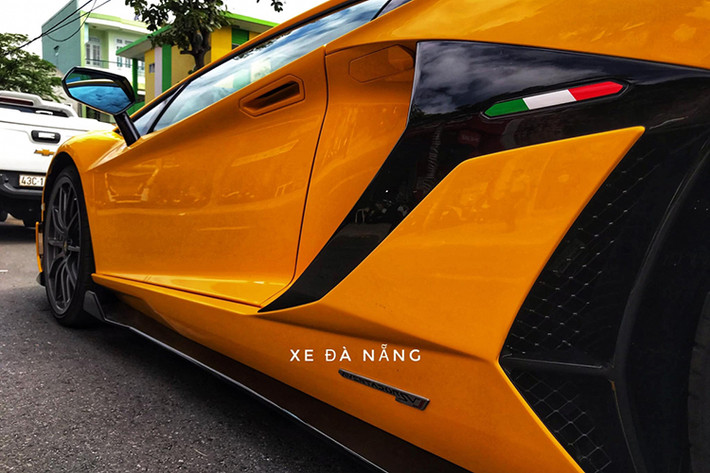 Bên hông siêu xe Lamborghini Aventador SVJ thứ 2 xuất hiện tại Việt Nam có thêm dải sọc 3 màu trắng, xanh lá cây và đỏ tượng trưng cho Quốc kỳ Ý, logo Aventador SVJ khá nhỏ ở sườn xe và khá bất ngờ là xe không có bộ tem SVJ nổi bật trên vòm bánh xe sau như chiếc Lamborghini Aventador SVJ đầu tiên về nước.