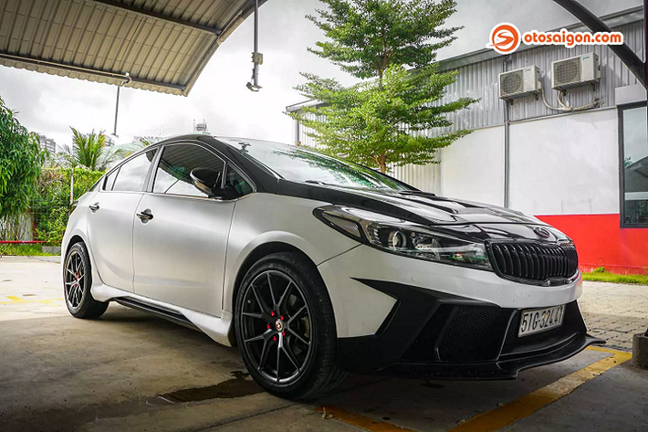 Body xe được wrap lại với 2 tông màu đen/ trắng ngọc trai. Ở phía trước, chiếc Kia Cerato 2017 cũ trang bị líp cản trước mở rộng hầm hố hơn với các khe gió lớn cùng những đường cắt táo bạo. Nắp capo cũng được độ lại với hàng loạt khe gió lạ mắt. Tuy nhiên chúng chỉ mang tính trang trí, không dùng để tản nhiệt động cơ. Hệ thống đèn pha được độ lại với bóng bi-xenon trong khi đèn sau chỉ được dán khói.