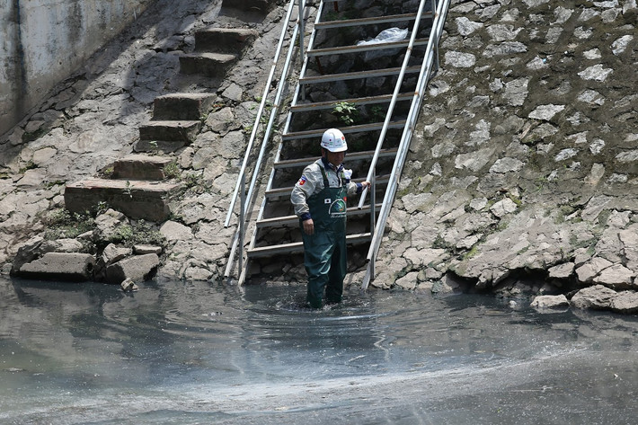 TS Kubo Jun - chuyên gia Nhật Bản (Cố vấn kỹ thuật Tổ chức xúc tiến thương mại - môi trường Nhật Bản, Chuyên gia công nghệ máy sục khí công nghệ nano JVE) bước xuống dòng nước đen xì của sông Tô Lịch (Hà Nội) khiến nhiều người bất ngờ và tò mò đổ ra xem.