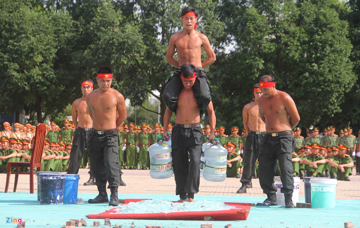 Trong khi đó, một chiến sĩ khác thực hiện màn nâng vật nặng đạp chân đi trên thủy tinh với trọng lượng mang trên người gần 200 kg.
