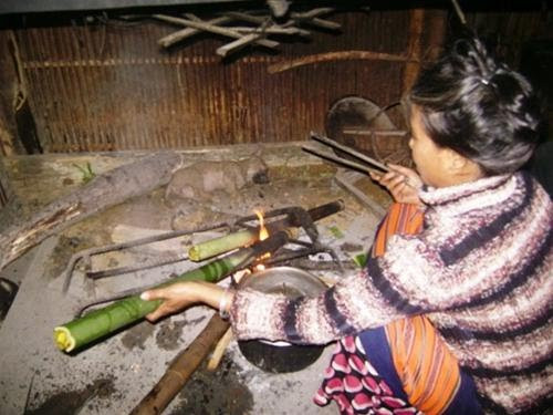 Trước khi nấu cơm lam, người Cơtu ngâm cho gạo mềm rồi cho vào từng ống một, lấy lá chuối non nút lại thật chặt và đặt trên bếp lửa đang cháy to. Sức nóng của lửa làm cho hơi nước sôi lên, toả mùi thơm ngát. Ảnh: vncgarden