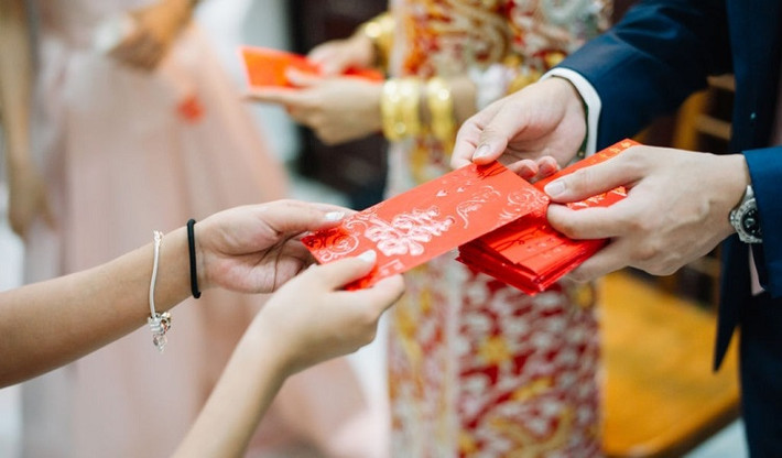 Tết năm ấy, có 8 vị tiên dạo qua nhà, biết trước cậu bé này sẽ gặp tai họa với yêu quái liền hóa thành 8 đồng tiền, ngày đêm túc trực bên bé. Sau khi cậu bé ngủ say, hai vợ chồng lấy giấy đỏ gói những đồng tiền này lại, đặt lên gối con rồi đi ngủ.