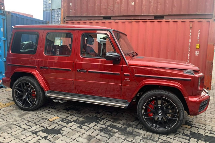 Chiếc SUV hạng sang Mercedes-AMG G63 này được nhập khẩu không chính hãng nên vẫn sở hữu cặp ống xả kép bên hông phải của xe đưa ra bên hông. Nhìn bên ngoài chiếc SUV hạng sang Mercedes-AMG G63 mới về nước ngoài màu đỏ nổi bật còn có nhiều chi tiết được sơn đen tạo điểm nhấn. La-zăng của chiếc xe SUV hạng sang Mercedes-AMG G63 này loại đa chấu kép sơn đen nhám kết hợp cùng kẹp phanh màu đỏ.