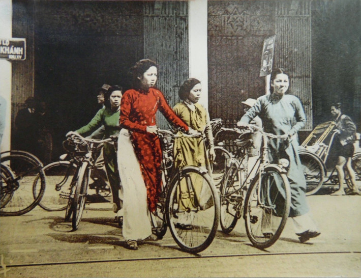 Các thiếu nữ áo dài dắt xe đạp trên đại lộ Đồng Khánh, nay là phố Hàng Bài, thập niên 1950.