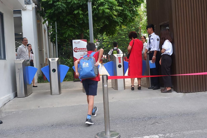 Các học sinh nhanh chân bước vào trường tham dự lễ khai giảng.