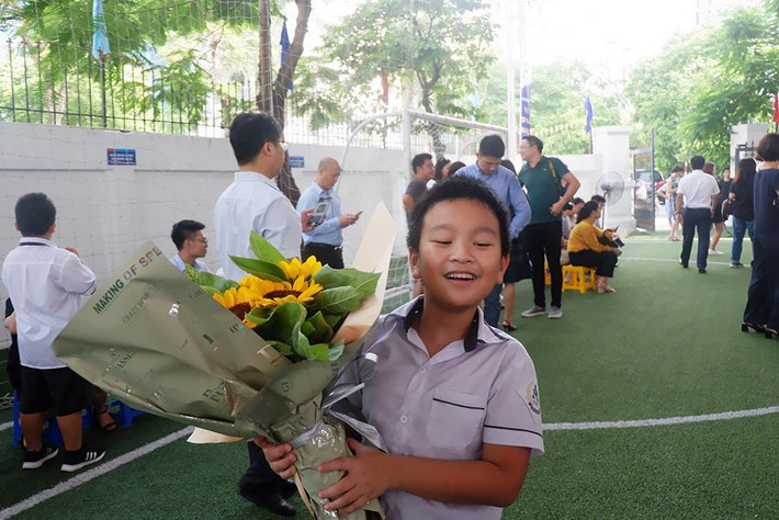 Cậu học trò cười vui khi nhận được bó hoa.