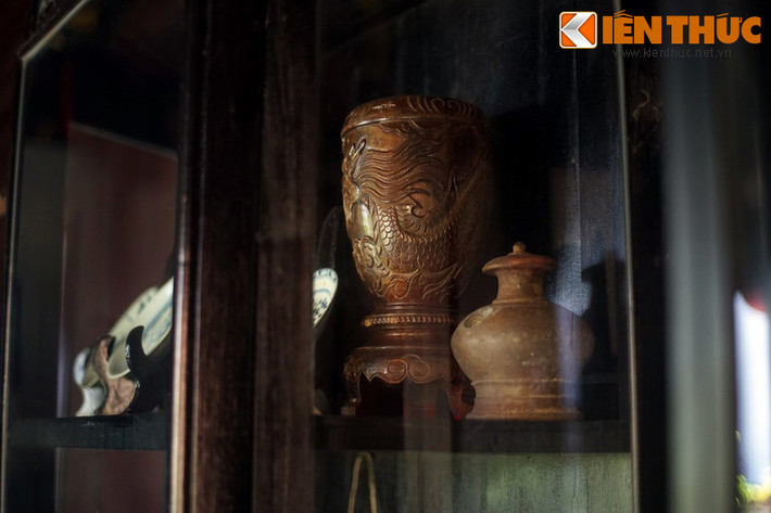 Nhiều vật dụng cổ của gia tộc được cất trữ trong tủ kính, trong đó có cặp bình hoa bằng gỗ được chạm nổi hình rồng có niên đại hơn 100 năm.