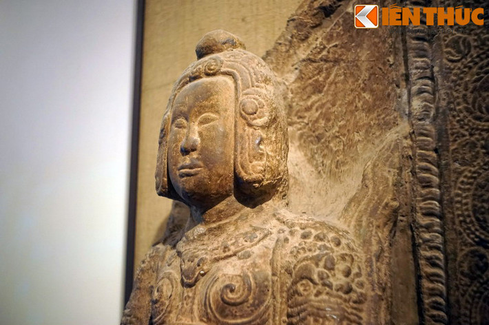 Giữa trán và chóp mũ nổi lên những đường gờ tạo thành hình vòng nối xuống những bông hoa cúc cách điệu hai bên mang tai.