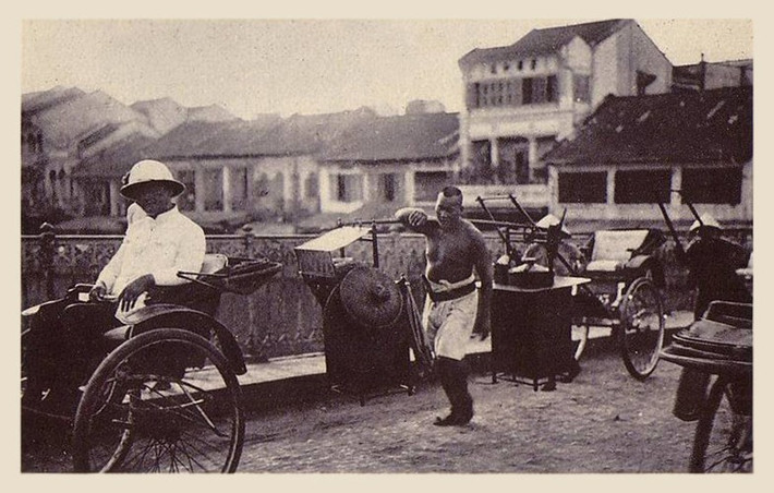 Người bán hàng rong đi qua một cây cầu ở Chợ Lớn. Ảnh: Public Domain.