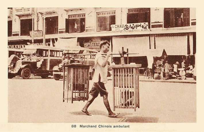 Người bán tàu hủ rong đi qua đường Schroder, nay là đường Phan Châu Trinh phía bên trái chợ Bến Thành, Sài Gòn một thế kỷ trước. Ảnh: Public Domain.