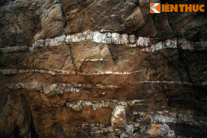 Giữa bề mặt đá màu nâu trầm, các sọc trắng tinh hiện ra theo thớ dọc, ngang, trông xa tưởng như có ai nghịch ngợm dùng vôi trắng quét lên.