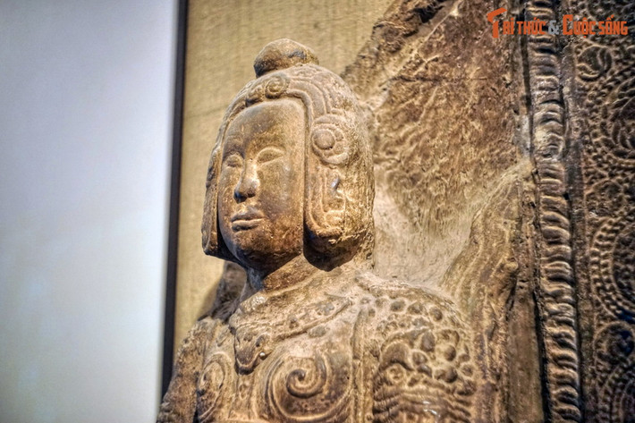 Tượng được tạc bằng sa thạch nguyên khối, với dáng võ quan khỏe mạnh, đầu đội mũ có chỏm tròn trên đỉnh, bó sát đầu, ôm lấy hai bên mang tai cho đến tận cằm. Thân tượng vận giáp trụ, bó sát người xuống tận dưới đầu gối, ngực áo có hai xoáy lớn.