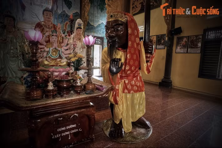 Tượng Ông Đỏ cao 2 mét 42, tay trái cầm binh khí, tay phải đưa cong ngang trước ngực, bắp tay đeo chuỗi hạt có hình cánh sen ở giữa, cổ chân trái đeo hình rắn Naga, cổ chân phải đeo vòng kiềng có hình cánh sen ở giữa.