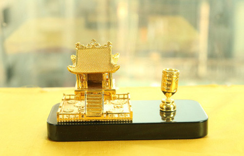 Biểu tượng Chùa Một Cột cùng với ao hình vuông phía dưới biểu tượng cho đất (trời tròn, đất vuông) và bên cạnh là giá cắm bút được phủ vàng 24K.